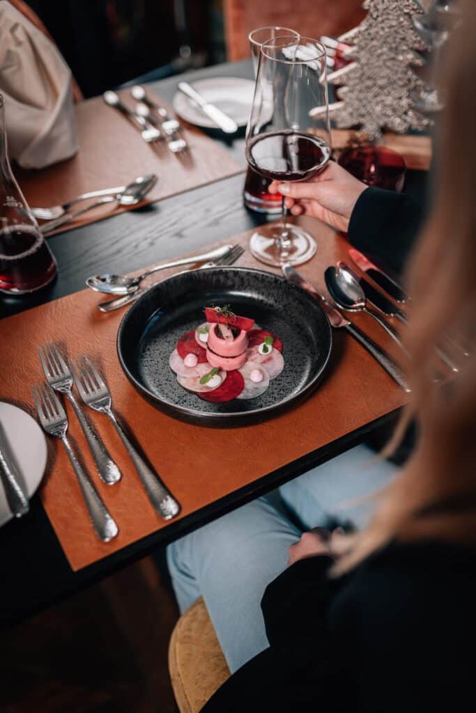Gourmetgericht auf einem Tisch mit Weinglas und Besteck